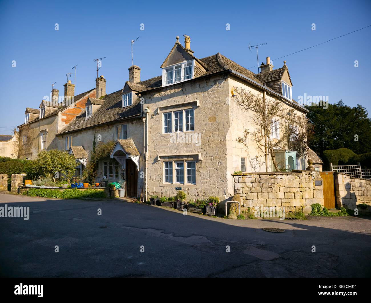 Sunlit Narrow Cotswold Lane avec Honey Stone Houses et Lens Flare, Painswick Area, Gloucestershire, Angleterre - Image de stock capturée avec un smartphone