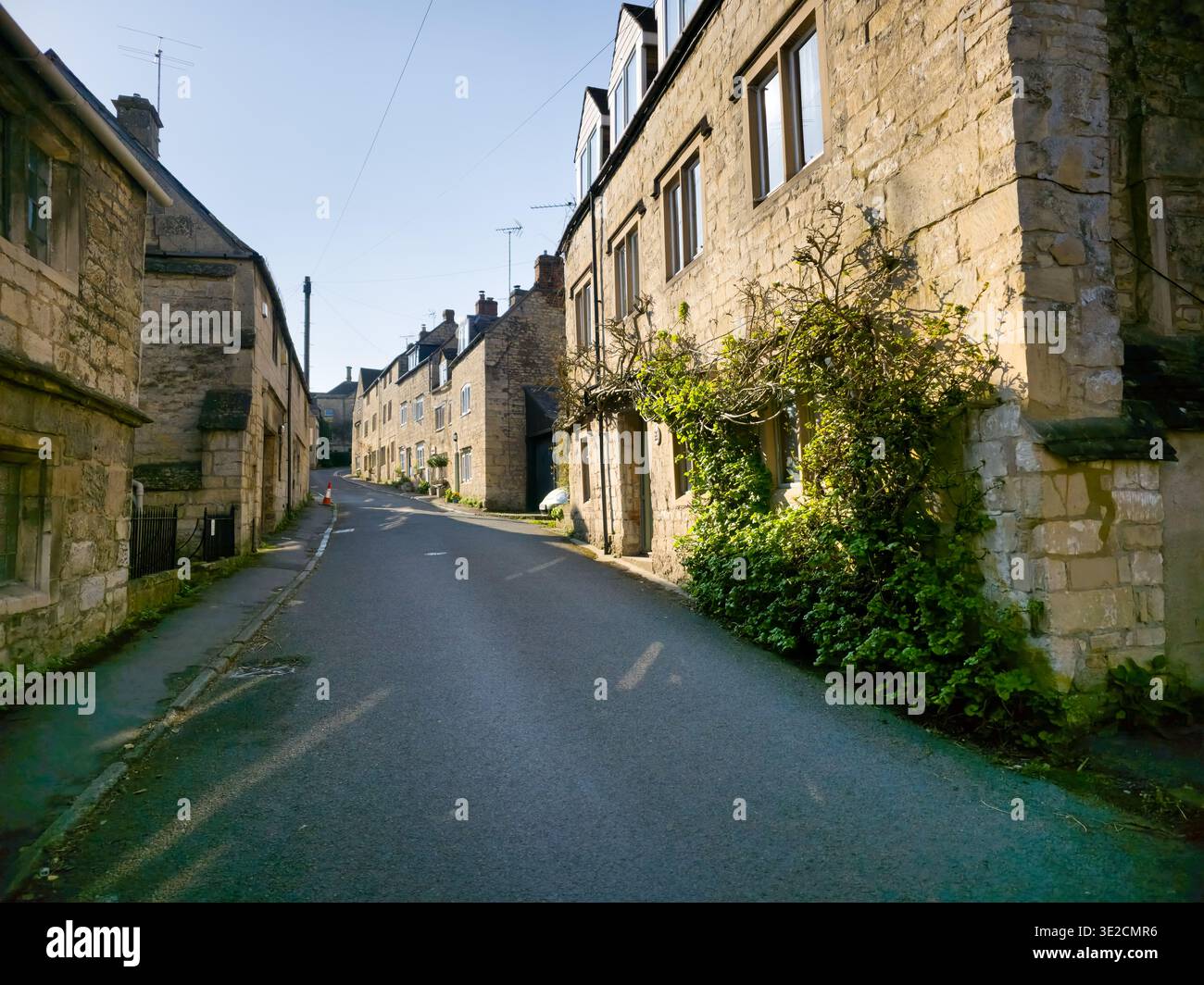 Sunlit Narrow Cotswold Lane avec Honey Stone Houses et Lens Flare, Painswick Area, Gloucestershire, Angleterre - Image de stock capturée avec un smartphone