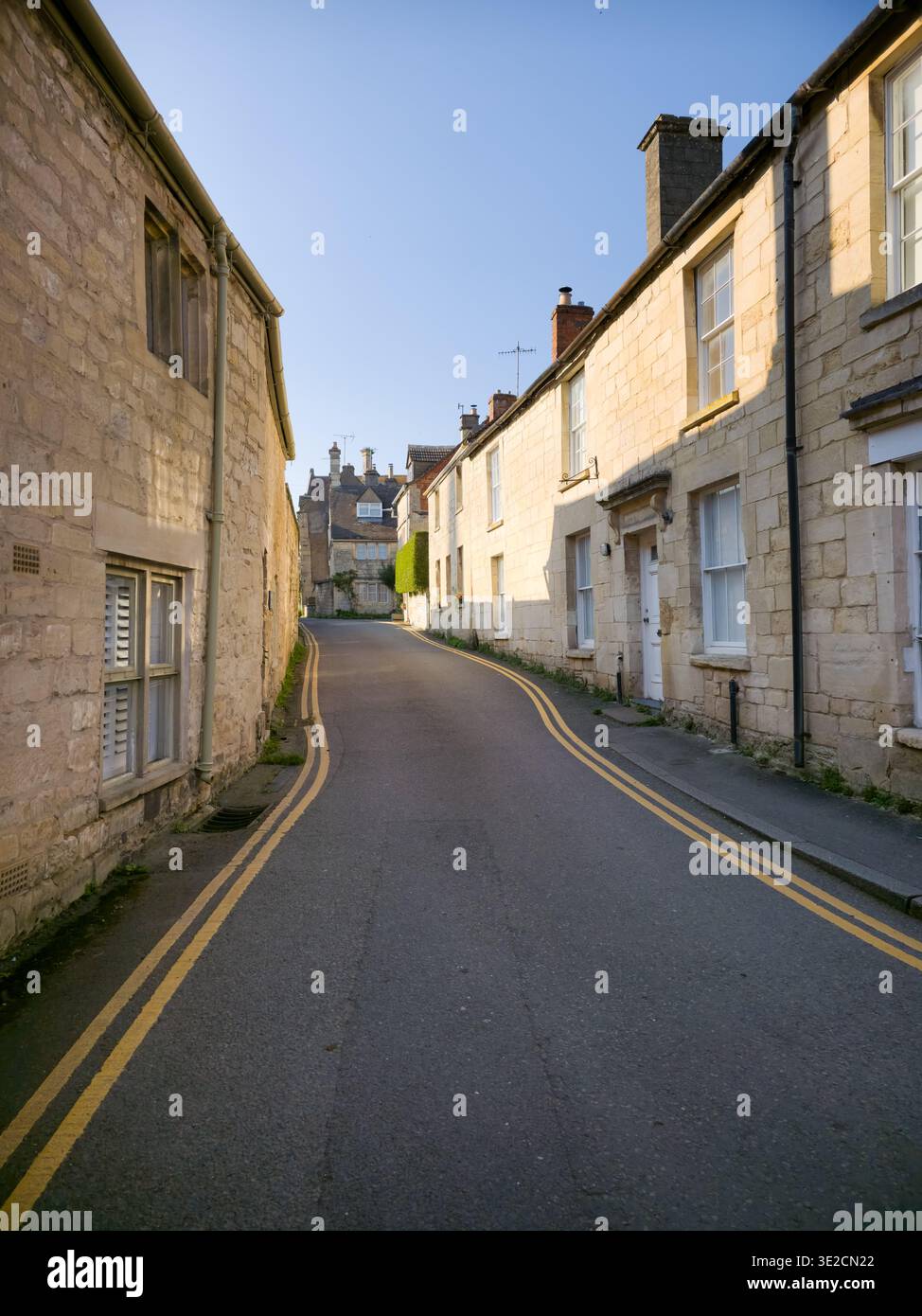 Sunlit Narrow Cotswold Lane avec Honey Stone Houses et Lens Flare, Painswick Area, Gloucestershire, Angleterre - Image de stock capturée avec un smartphone