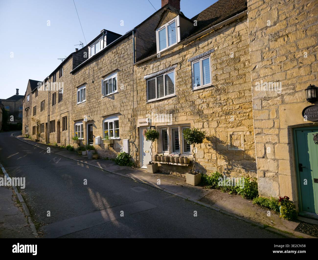 Sunlit Narrow Cotswold Lane avec Honey Stone Houses et Lens Flare, Painswick Area, Gloucestershire, Angleterre - Image de stock capturée avec un smartphone