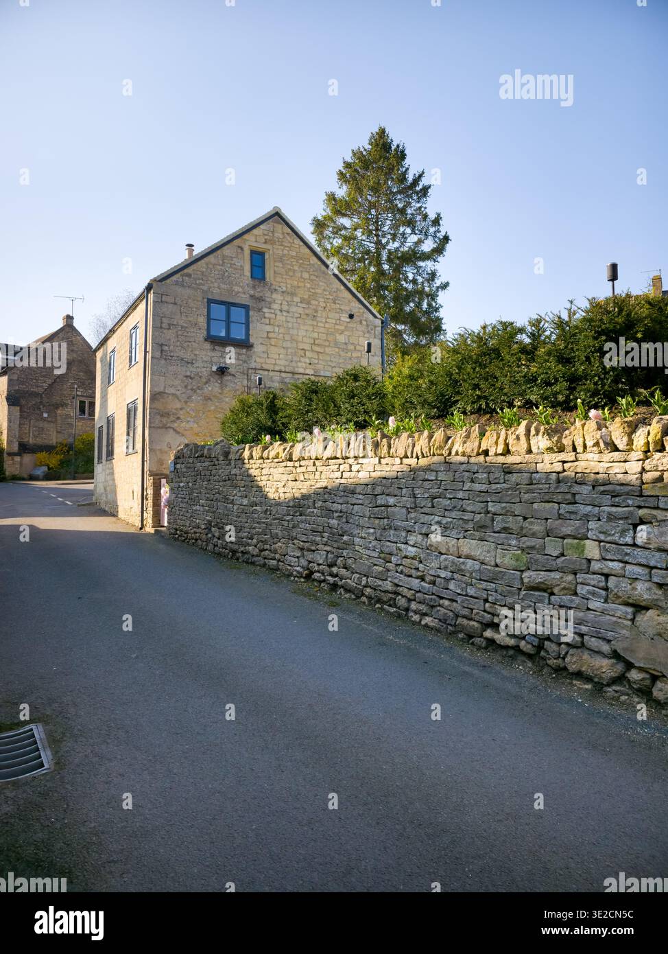 Sunlit Narrow Cotswold Lane avec Honey Stone Houses et Lens Flare, Painswick Area, Gloucestershire, Angleterre - Image de stock capturée avec un smartphone