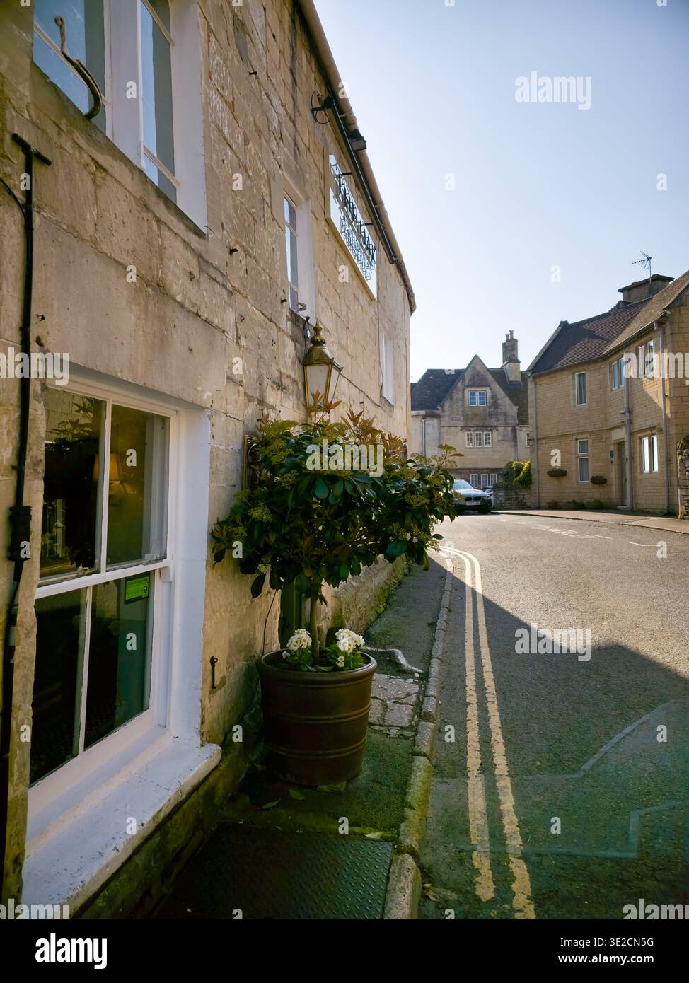Sunlit Narrow Cotswold Lane avec Honey Stone Houses et Lens Flare, Painswick Area, Gloucestershire, Angleterre - Image de stock capturée avec un smartphone