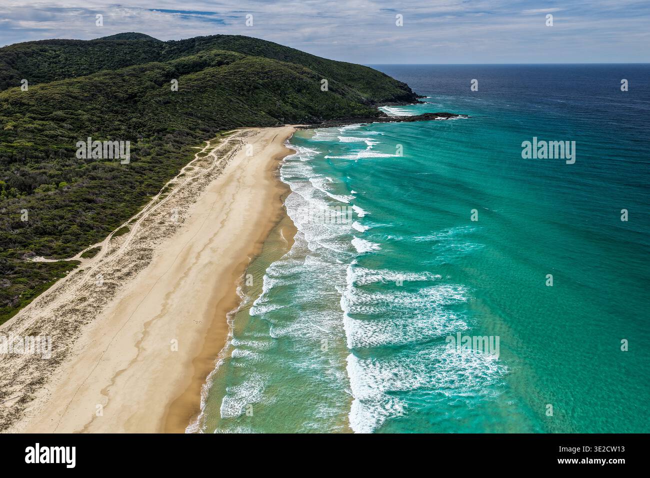 Vue aérienne par drone de Seven Mile Beach à Forster montrant une longue étendue de rivage sablonneux avec des vagues océaniques et des terres côtières naturelles environnantes Banque D'Images