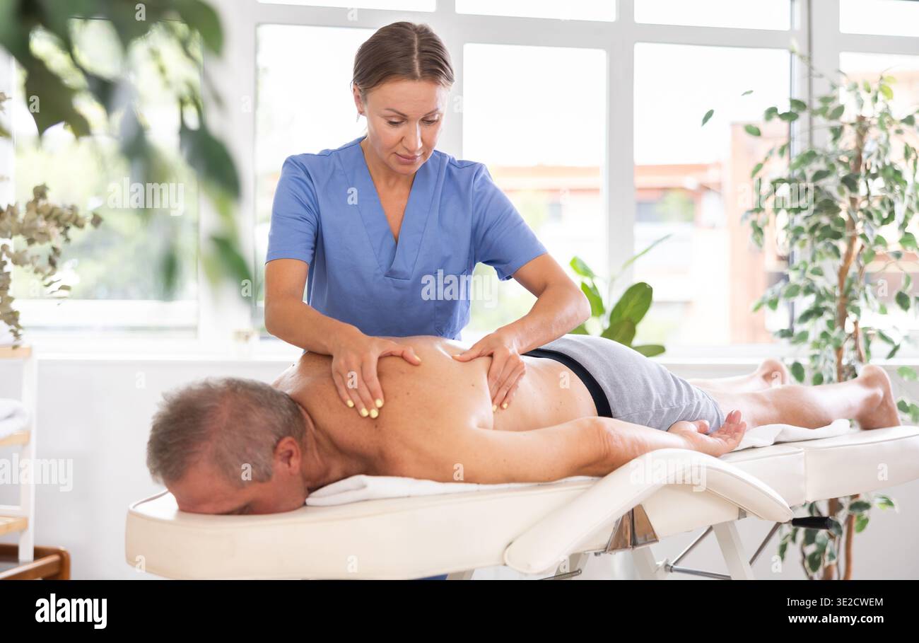 masseuse donnant massage à un patient masculin Banque D'Images