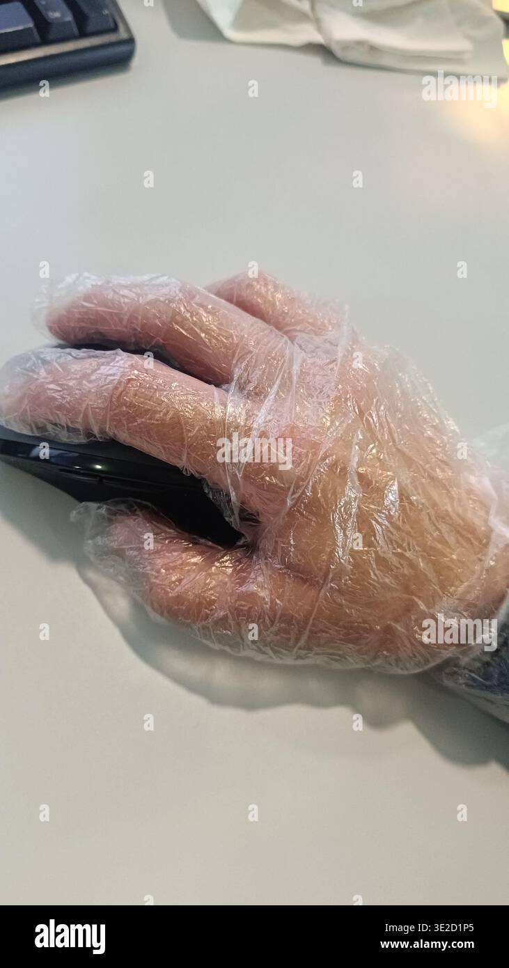 Utiliser un gant en plastique au bureau pour prévenir la contamination virale. Peur des virus et des maladies. Banque D'Images