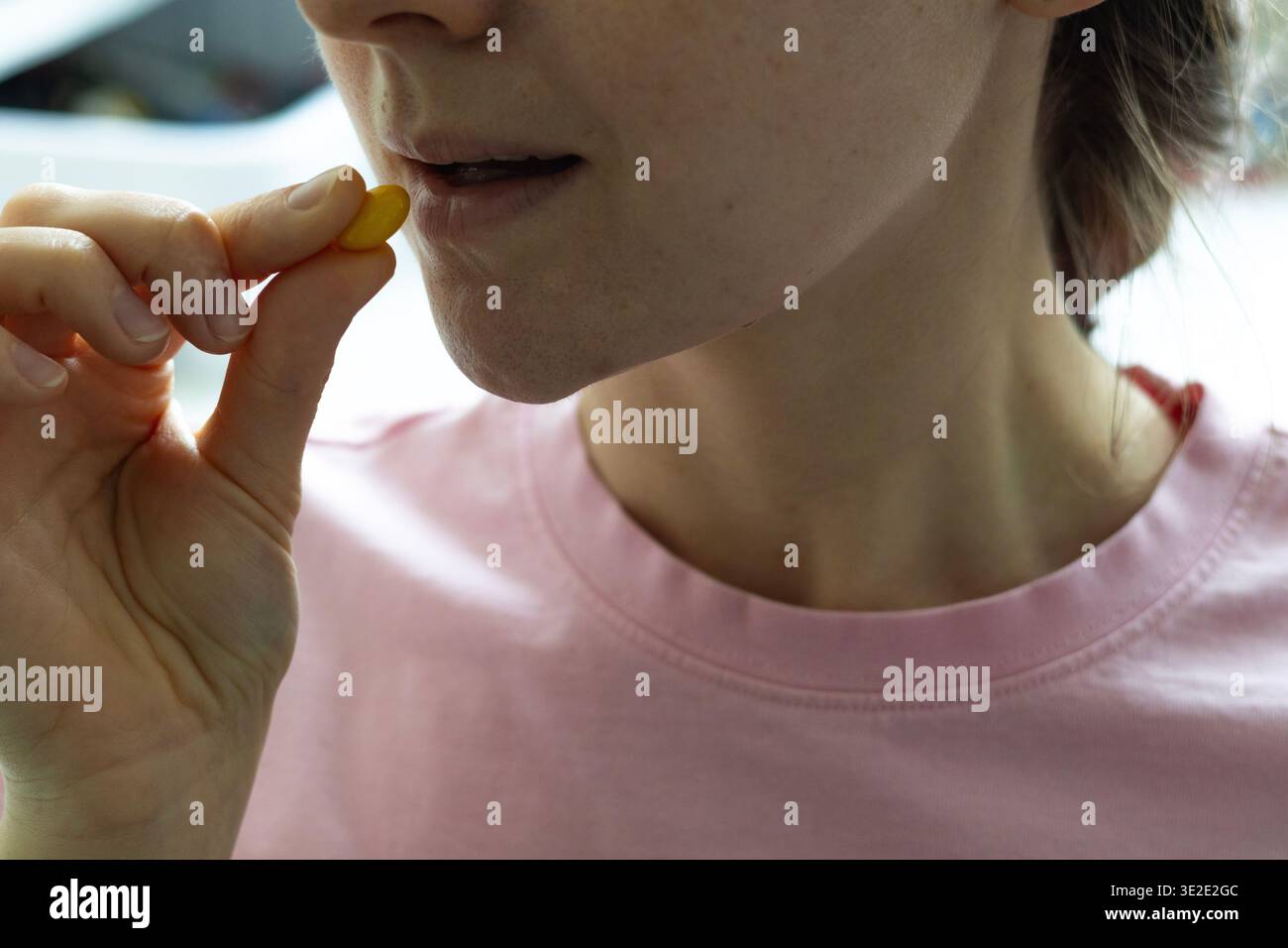 Gros plan d'une femme prenant une capsule de vitamine. Routine quotidienne de supplément, soins de santé, soutien immunitaire et concept de mode de vie sain Banque D'Images
