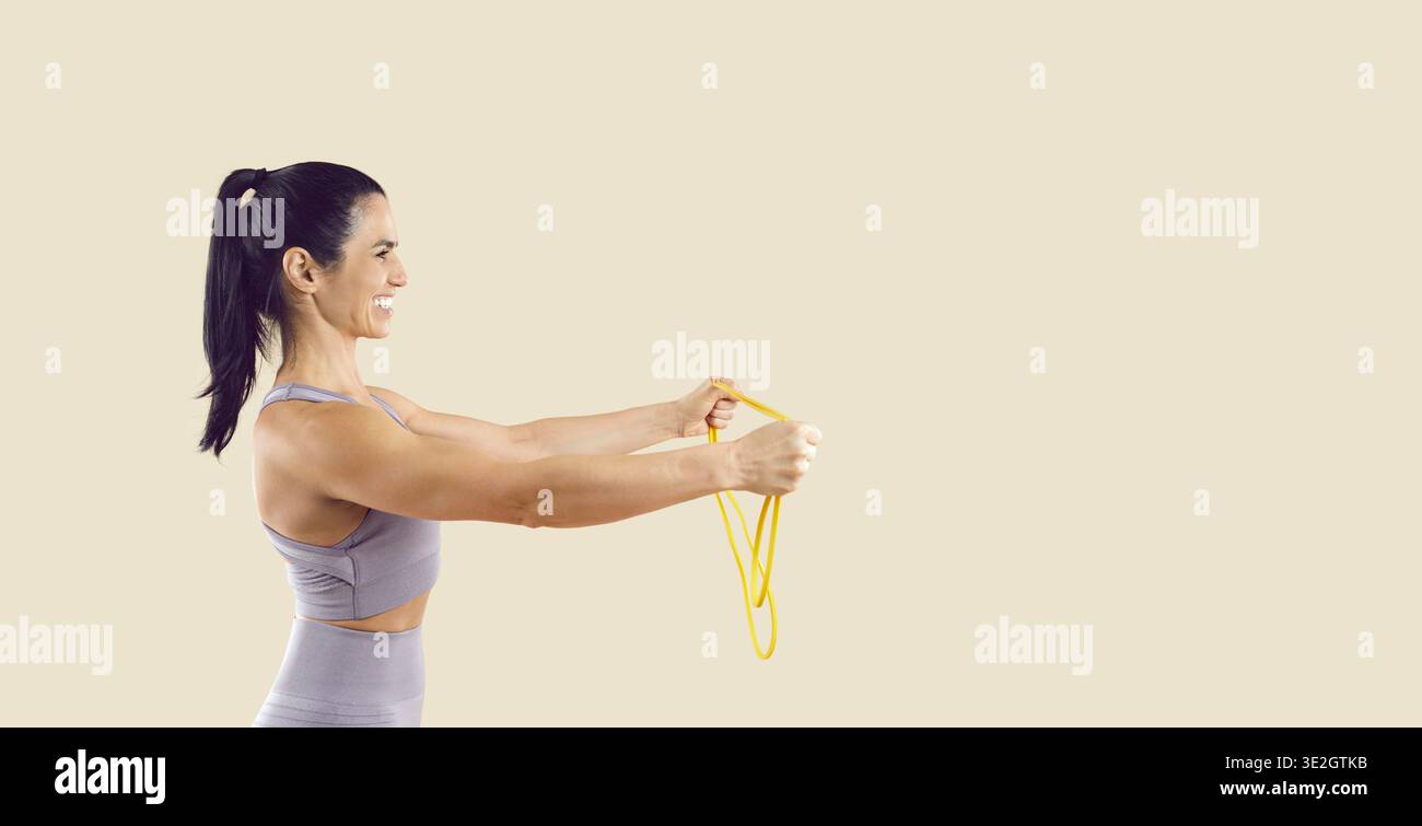 Formation de femme en forme avec bande de résistance jaune, vue latérale sur l'espace de copie beige Banque D'Images