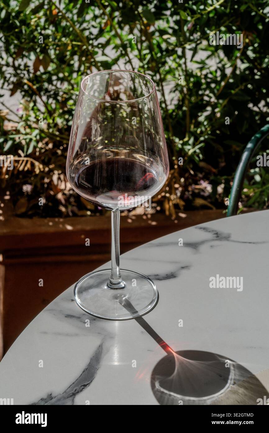 Verre de vin rouge sur la table de café en marbre extérieur Banque D'Images