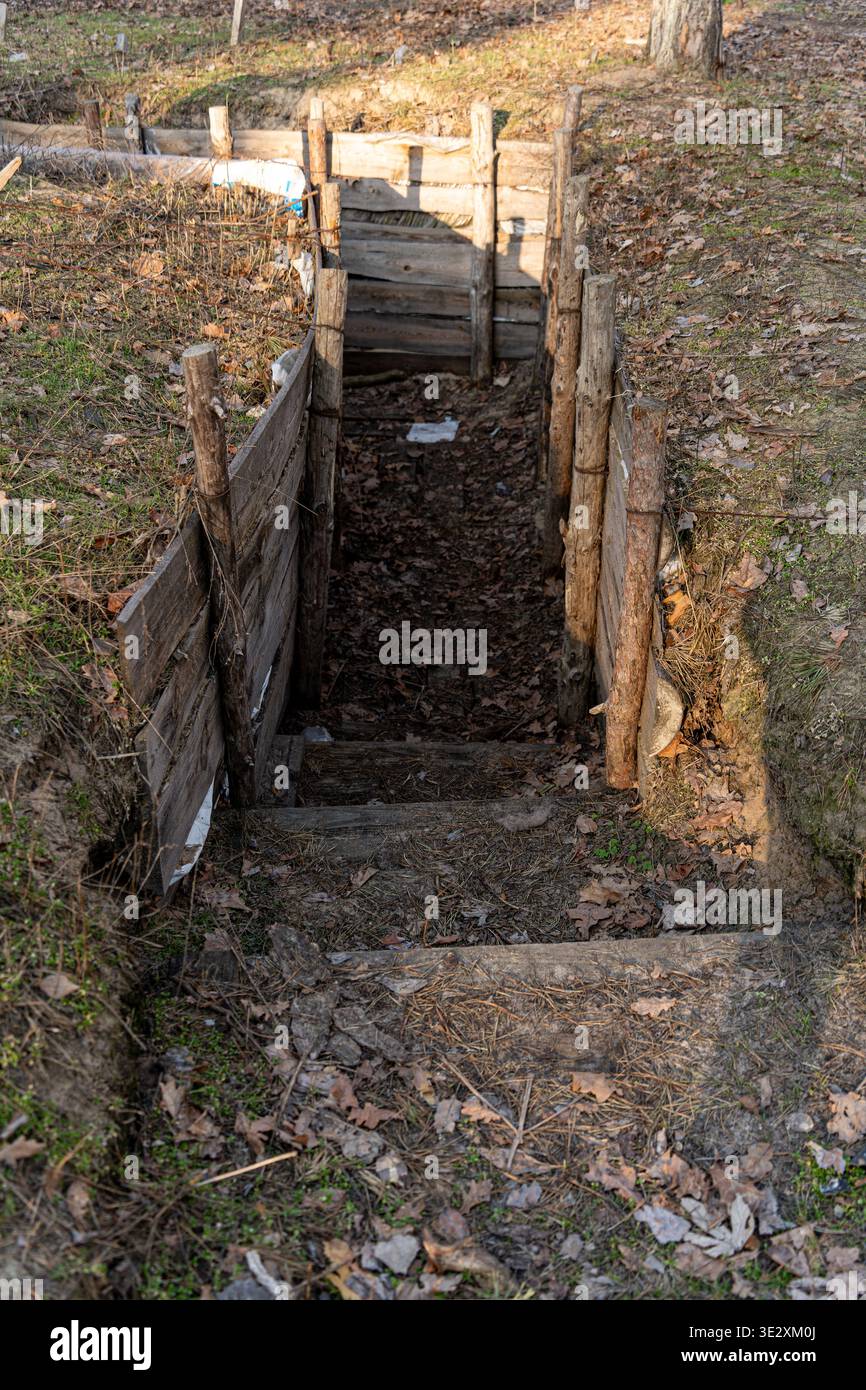 Vue d'une fosse avec des supports en bois et des marches descend dans la terre, un sombre rappel de résilience et de survie, Kiev, ville de Kiev, Ukraine. Banque D'Images