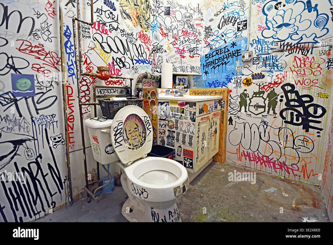 Salle de bain remplie de graffitis à Low Brow Artique, une galerie et un magasin de fournitures dans la section Bushwick de Brooklyn, New York - Banque D'Images