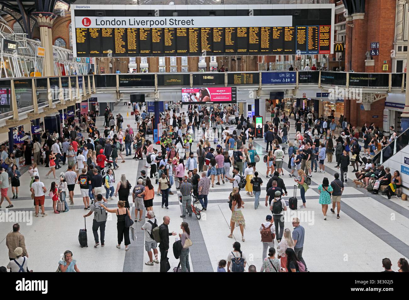 Halles animées et panneaux de départs à l'intérieur de la gare de Liverpool Street à Londres, un terminus majeur de la City de Londres. Banque D'Images