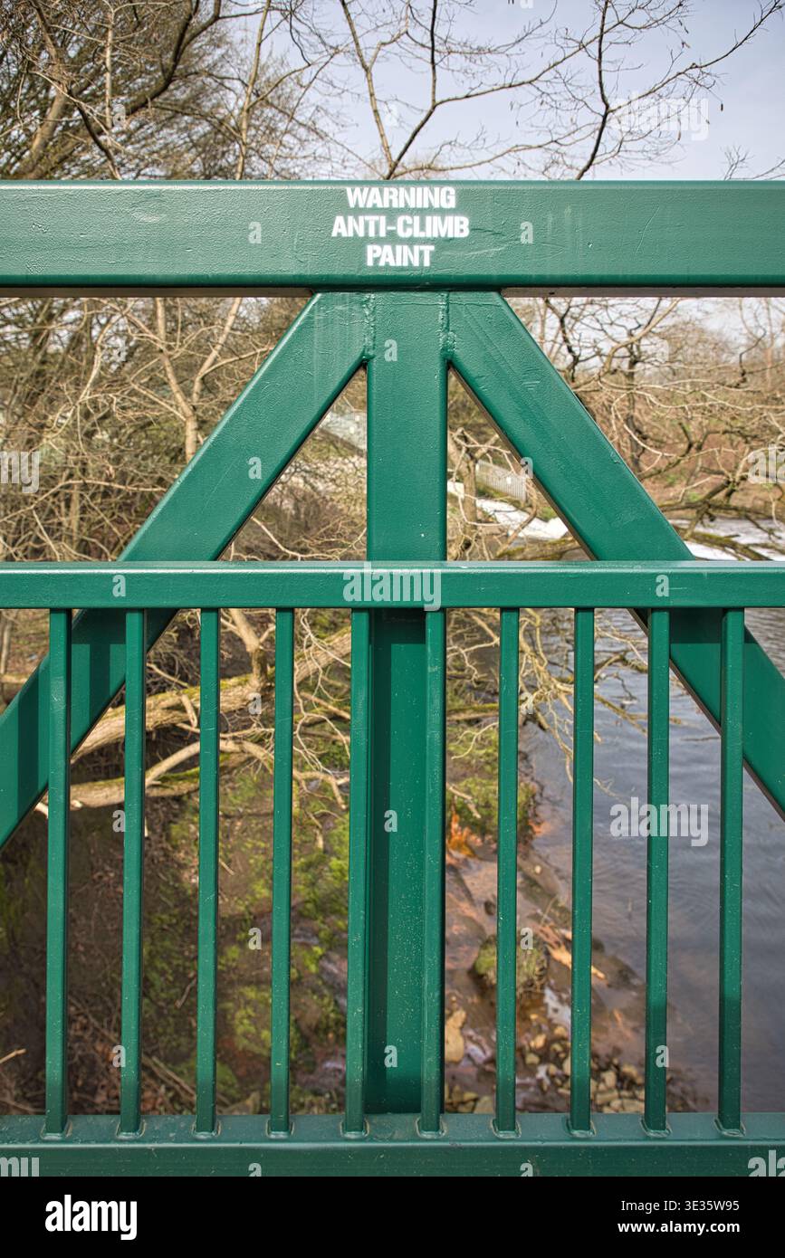 Avertissement avis de peinture anti-escalade au pochoir sur une passerelle Green Metal au-dessus de la rivière Irwell, Clifton Country Park, Salford, Royaume-Uni. Banque D'Images