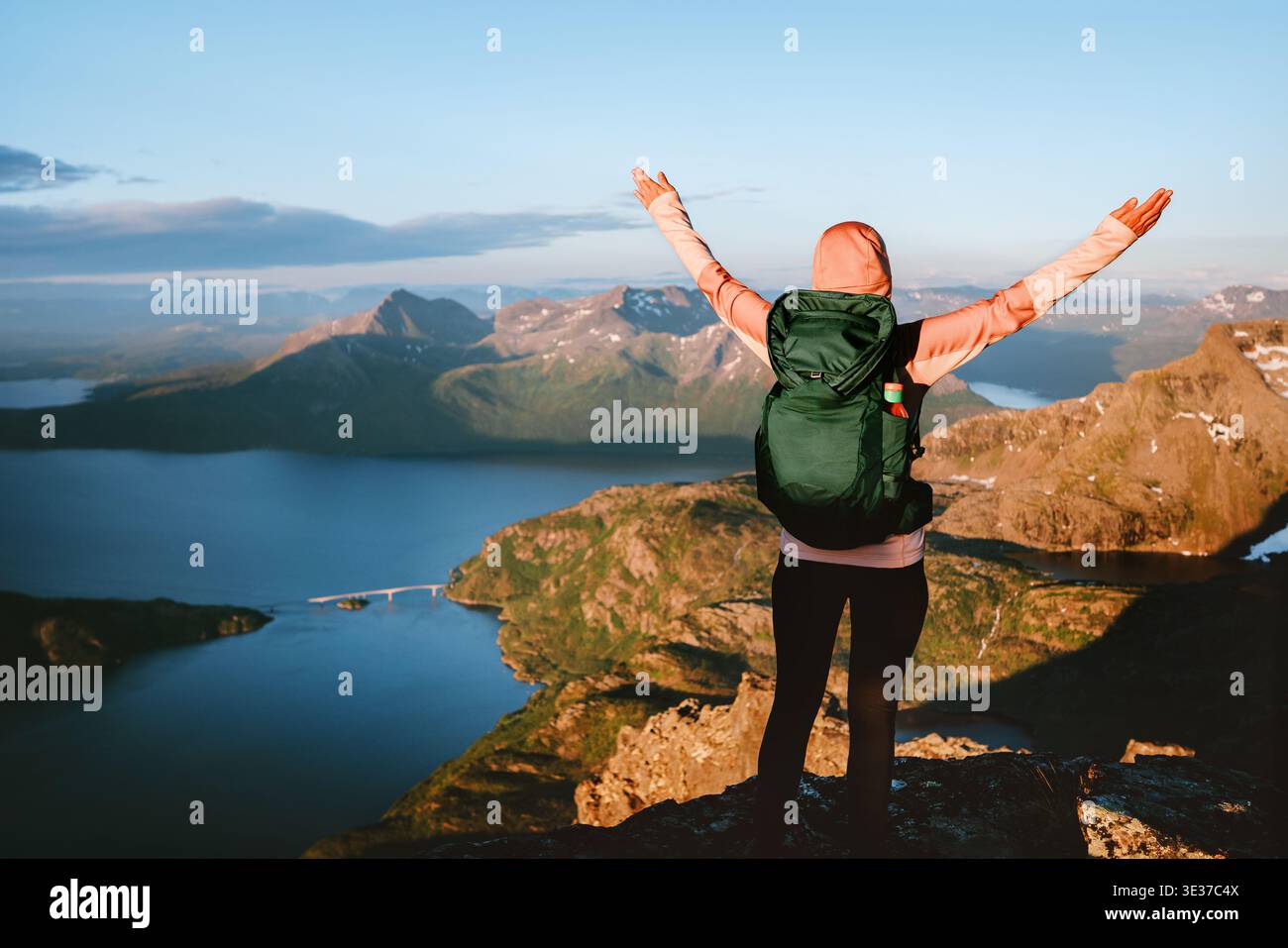 Heureuse femme touristique voyage en solo en Norvège fille sur le dessus les mains levées profitant des montagnes et de la vue aérienne de la mer, vacances d'été à l'extérieur de l'avènement actif Banque D'Images