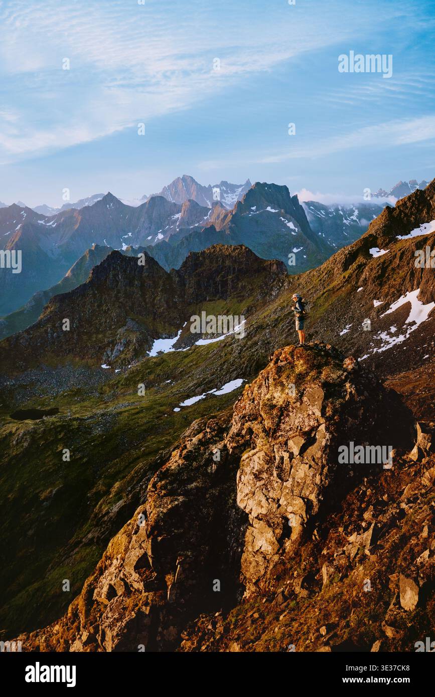 Homme voyage en solo debout sur la falaise rocheuse de montagne en Norvège grimpant des vacances d'été extrêmes dans les îles Lofoten aventure voyage en plein air sain vie Banque D'Images