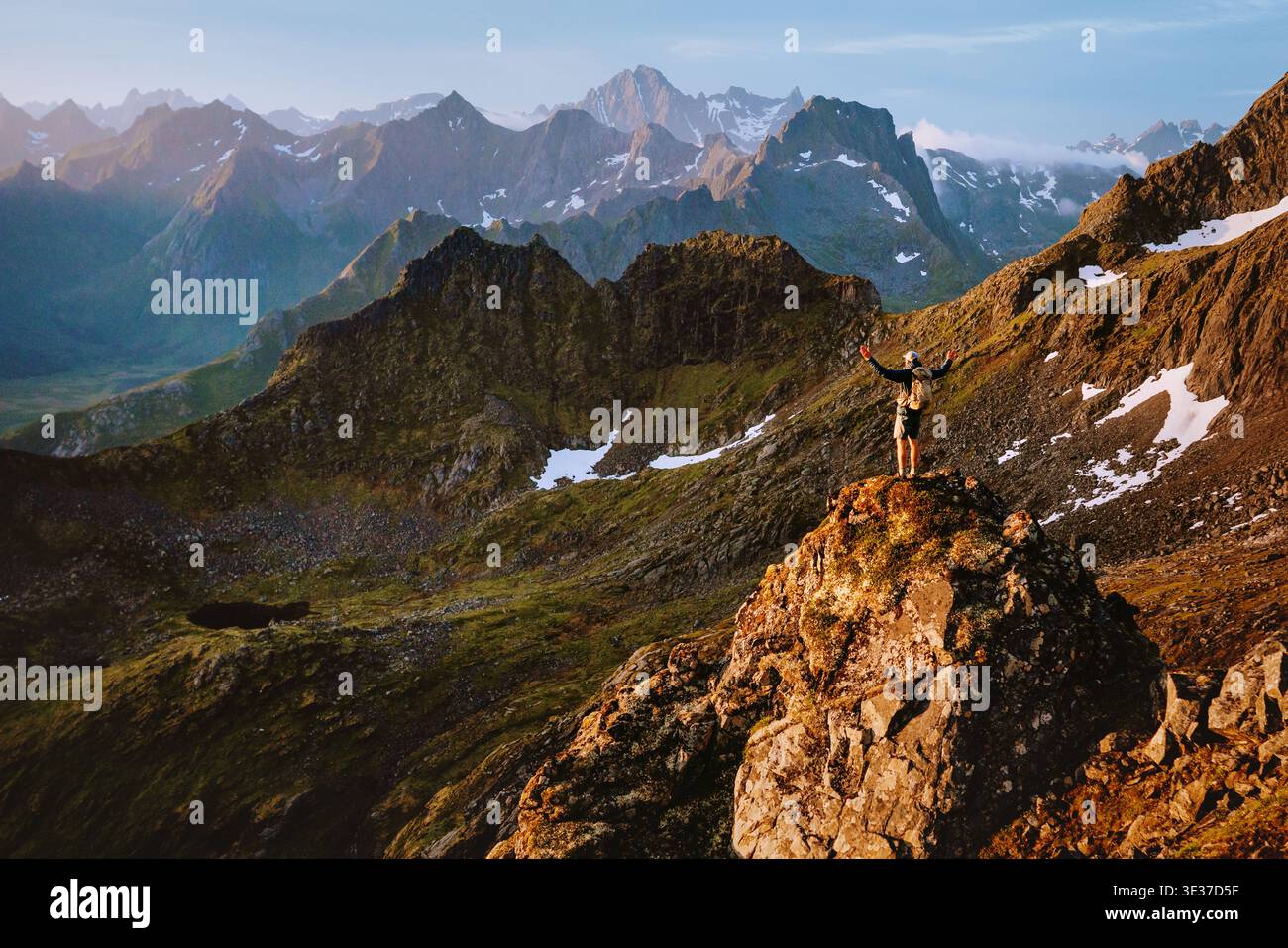 Alpiniste homme grimpant les montagnes en solo en Norvège voyage concept de liberté de style de vie, voyageur levé les mains debout sur la falaise profitant des îles Lofoten v Banque D'Images