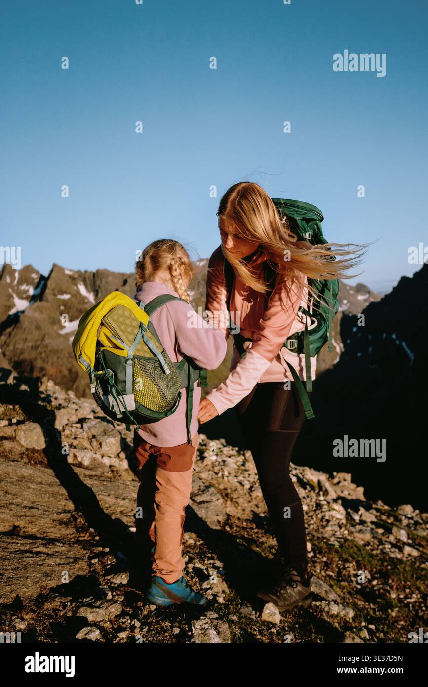 Parents et enfants partent ensemble en randonnée en famille pour des vacances d'été en Norvège - mère et fille grimpant la montagne dans les îles Lofoten excursion d'un week-end actif Banque D'Images