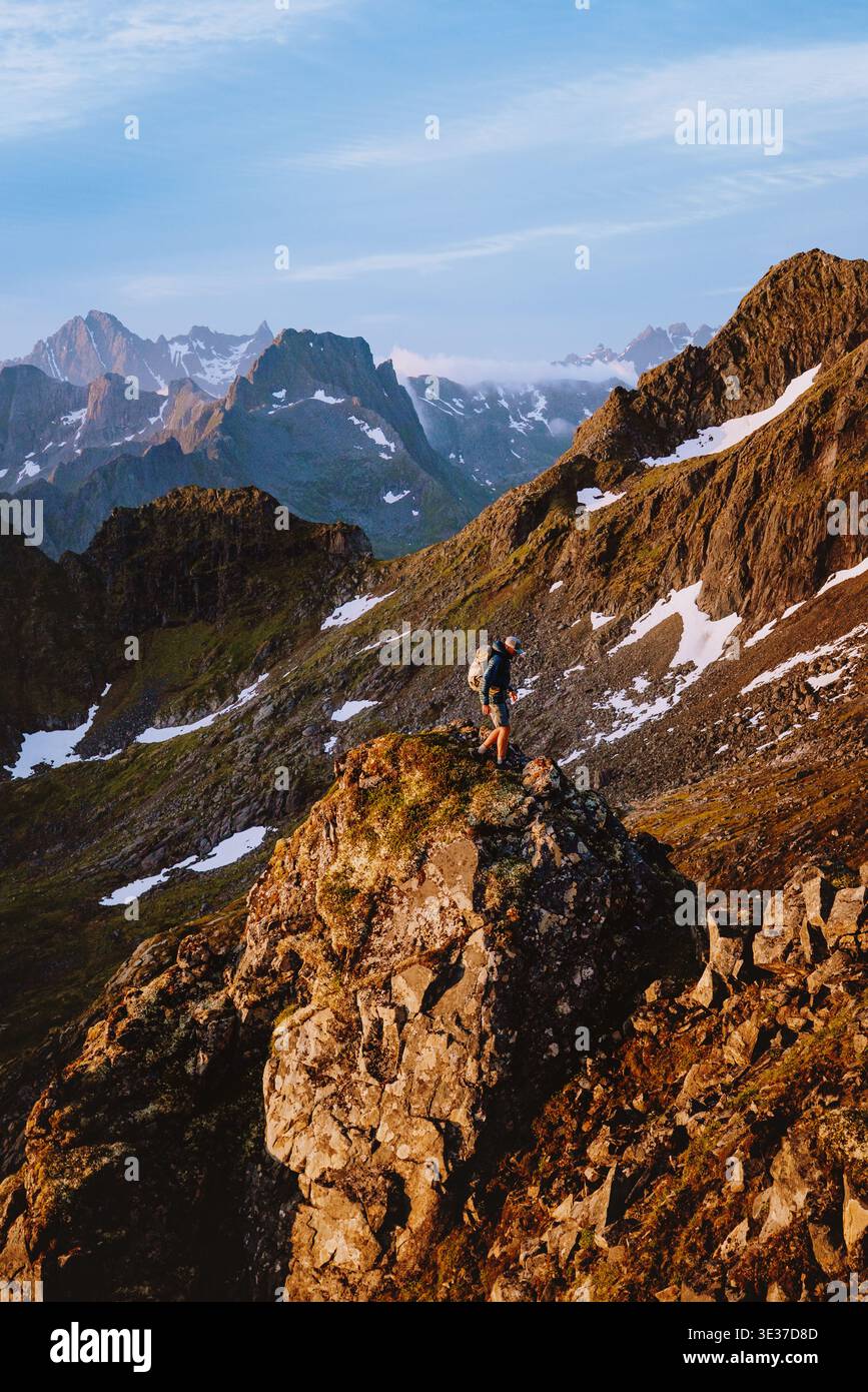 Homme voyage en solo escalade des montagnes dans le nord de la Norvège vacances d'été extrêmes dans les îles Lofoten, randonnée aventure voyageur de style de vie en plein air sur cli Banque D'Images