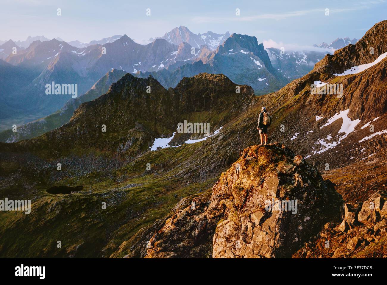 Homme escaladant les montagnes voyage en solo en Norvège vacances d'été dans les îles Lofoten, voyage d'aventure extrême randonnée debout seul en plein air sur cli Banque D'Images