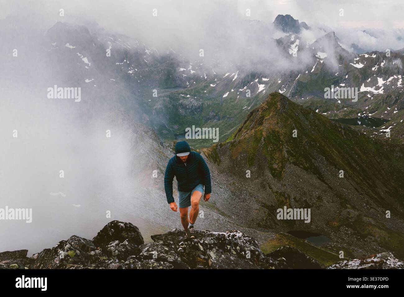 Homme escalade voyage de montagne en Norvège randonnée en solo dans les îles Lofoten, brumeux nature aventure estivale vacances extrêmes voyageur trekking voyage en plein air f Banque D'Images