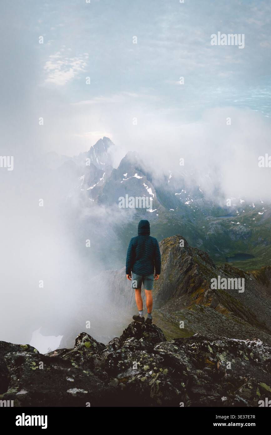 Homme grimpeur voyage en Norvège grimpant des montagnes brumeuses en solo dans les îles Lofoten, vacances d'été aventure voyageur en plein air sur la liberté de voyage de randonnée et Banque D'Images