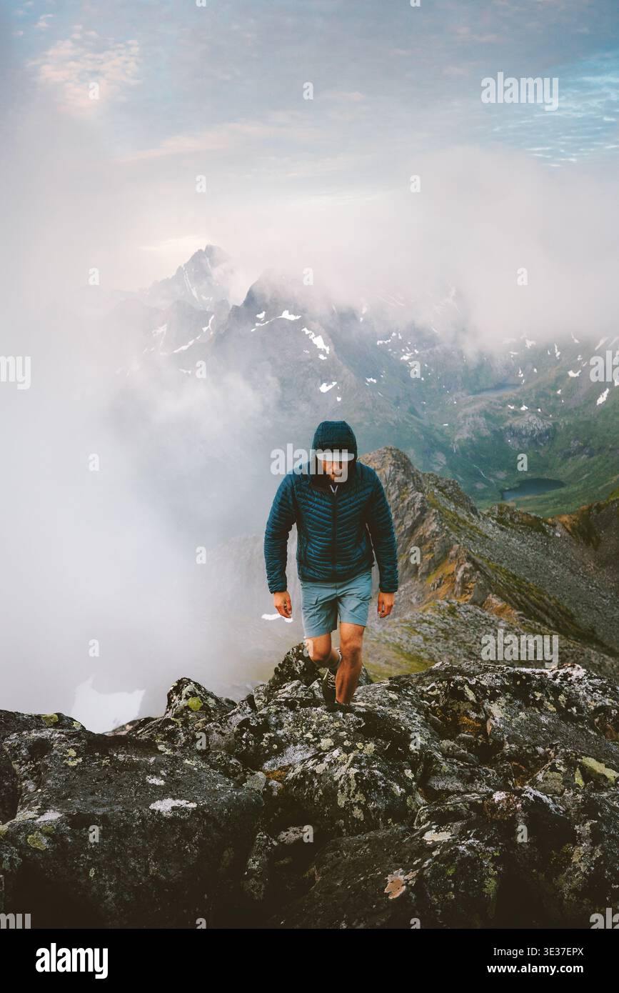 Homme actif randonneur grimpant les montagnes brumeuses voyage en Norvège style de vie sain vacances extrêmes dans les îles Lofoten aventure tour en plein air, voyageur mou Banque D'Images