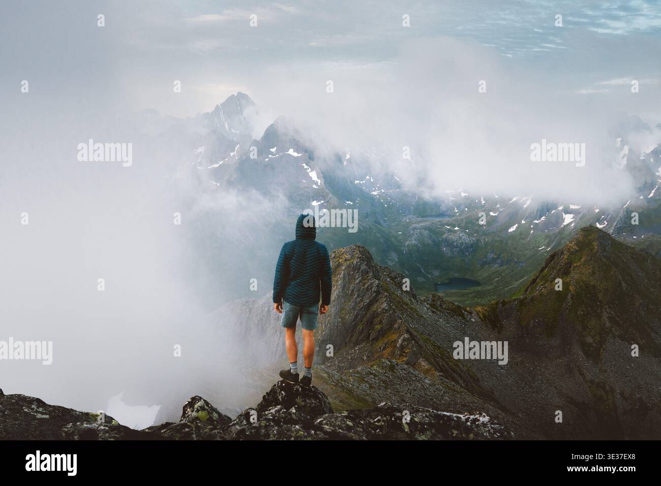 Homme voyage touristique en Norvège en solo debout sur la falaise grimpant des montagnes brumeuses dans les îles Lofoten, voyage d'aventure extrême randonnée de vacances d'été Banque D'Images