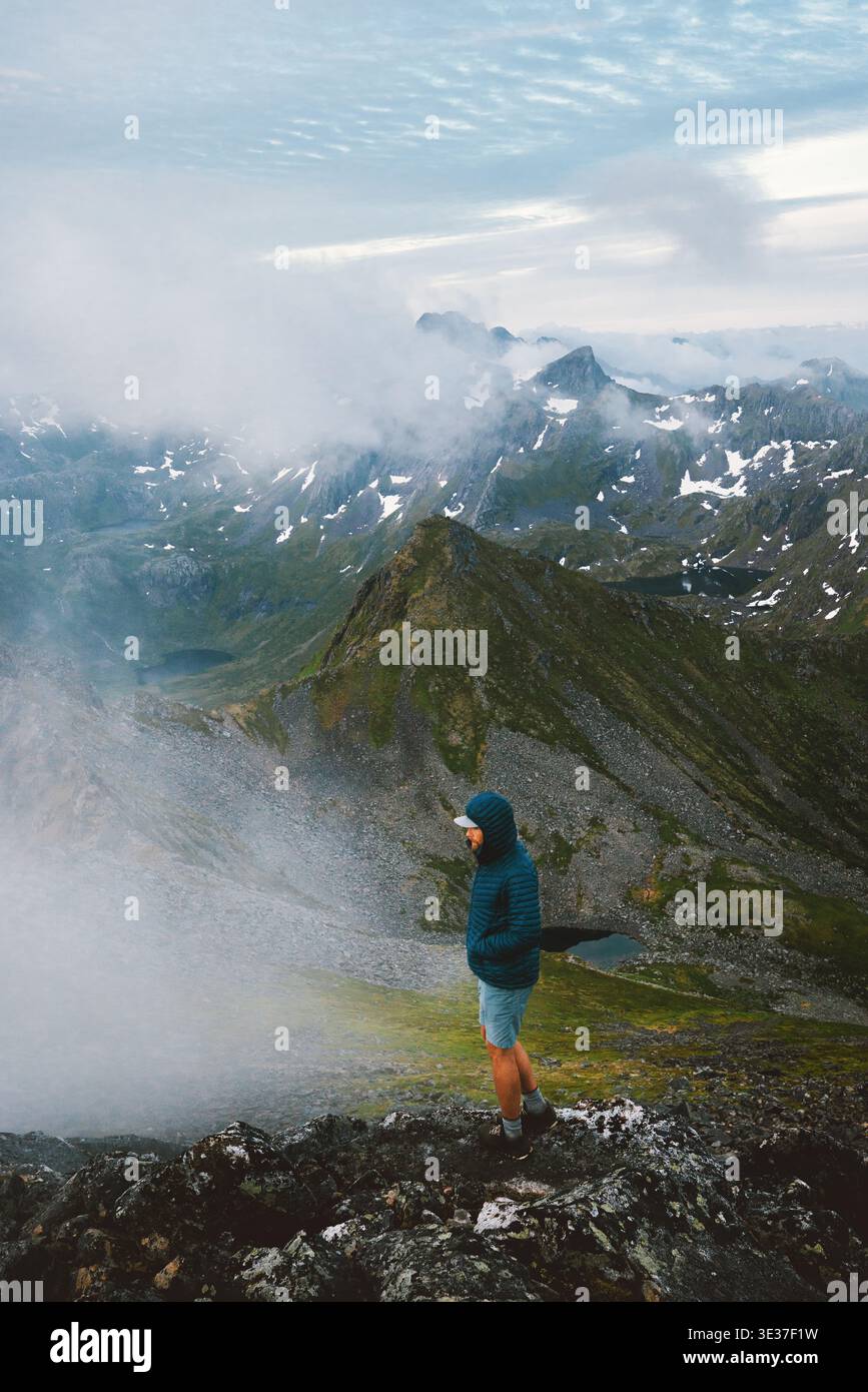 Homme voyageur randonnée montagnes brumeuses en Norvège voyage en solo dans les îles Lofoten, escalade aventure actif voyage d'été vacances extrêmes en plein air dans le w Banque D'Images
