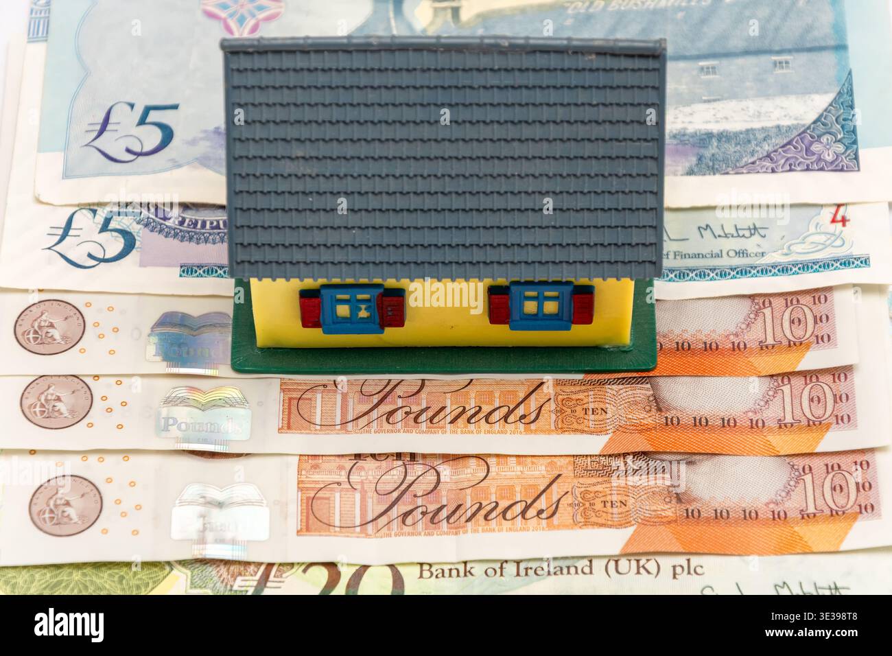 Maison de jouet sur la livre sterling symbolisant le marché immobilier britannique et l'investissement. Banque D'Images