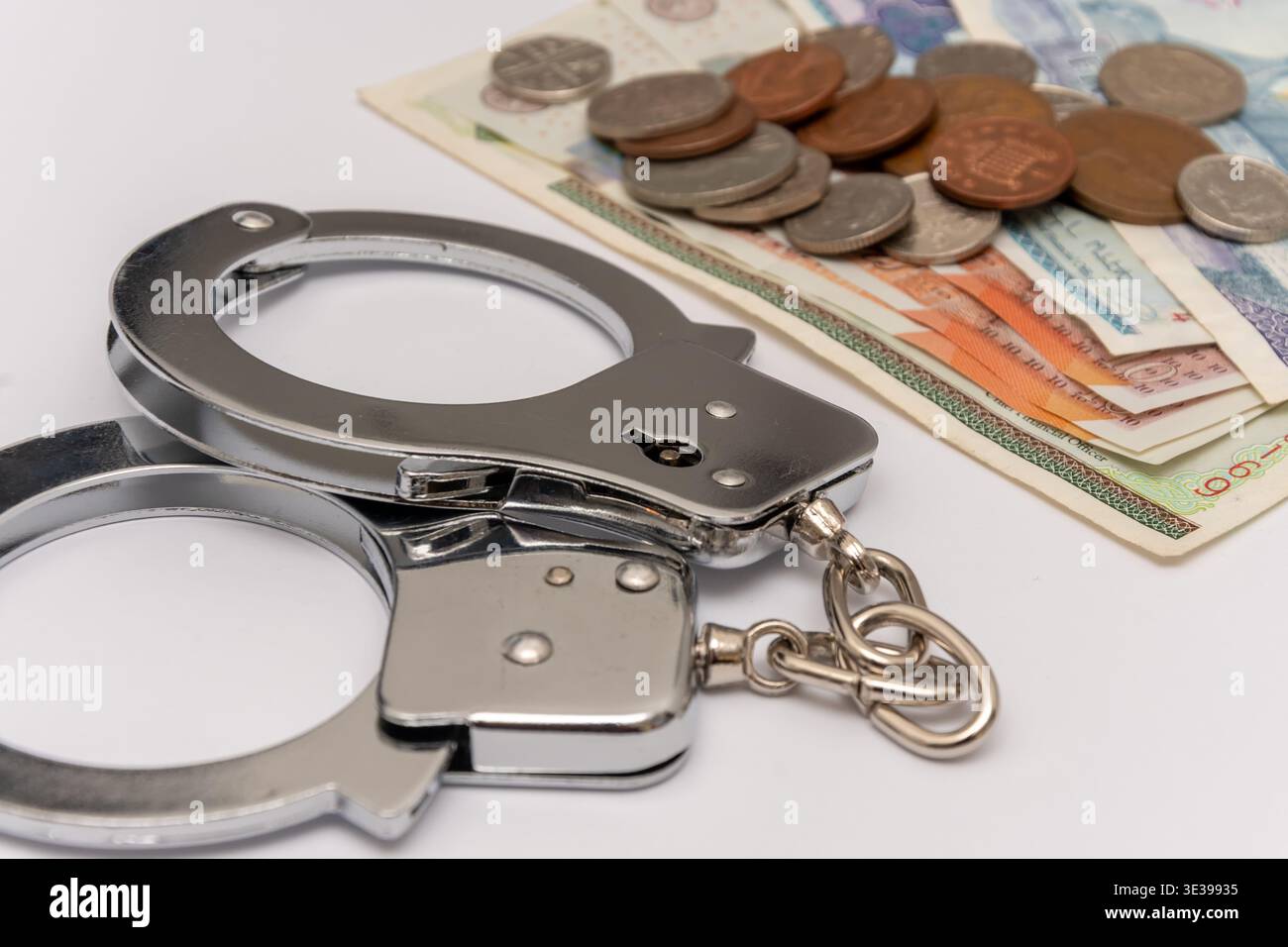 Argent britannique avec des menottes symbolisant l'arrestation frauduleuse et les violations économiques. Banque D'Images