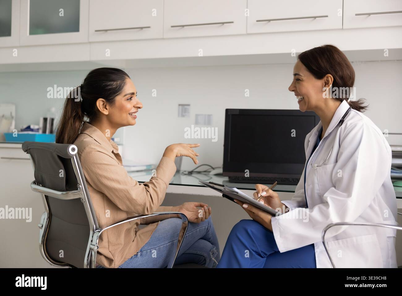 Médecin souriant consultant femme patiente en clinique Banque D'Images