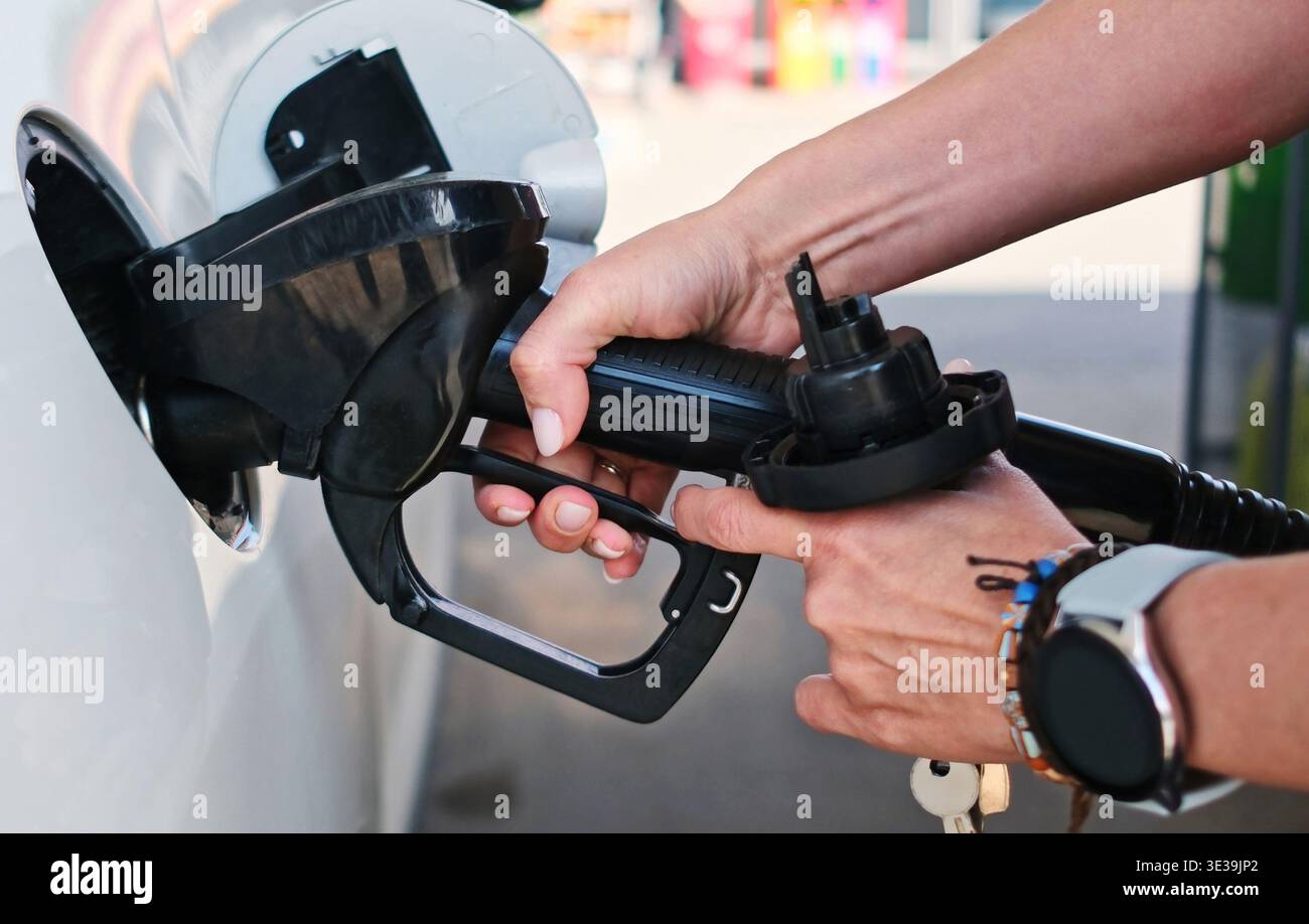 Fille met Une pompe à essence dans le réservoir de carburant d'Une voiture à Une station-service Banque D'Images
