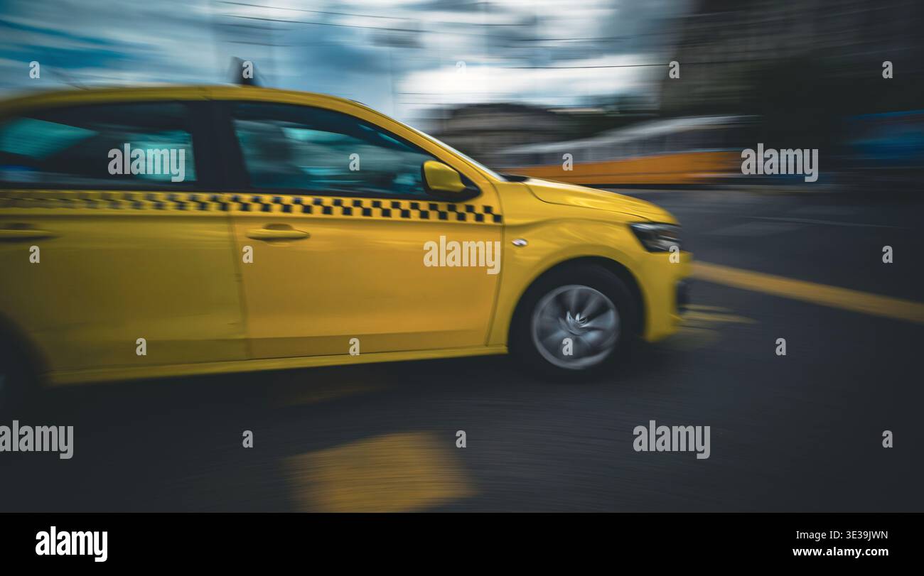 La voiture de taxi jaune précipitée conduit rapidement par la route de la ville avec Un effet de flou de mouvement Banque D'Images