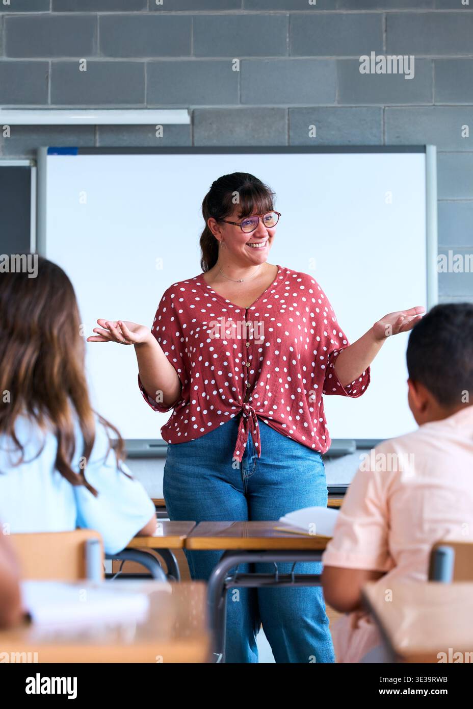 Enseignante souriante expliquant la leçon en classe Banque D'Images