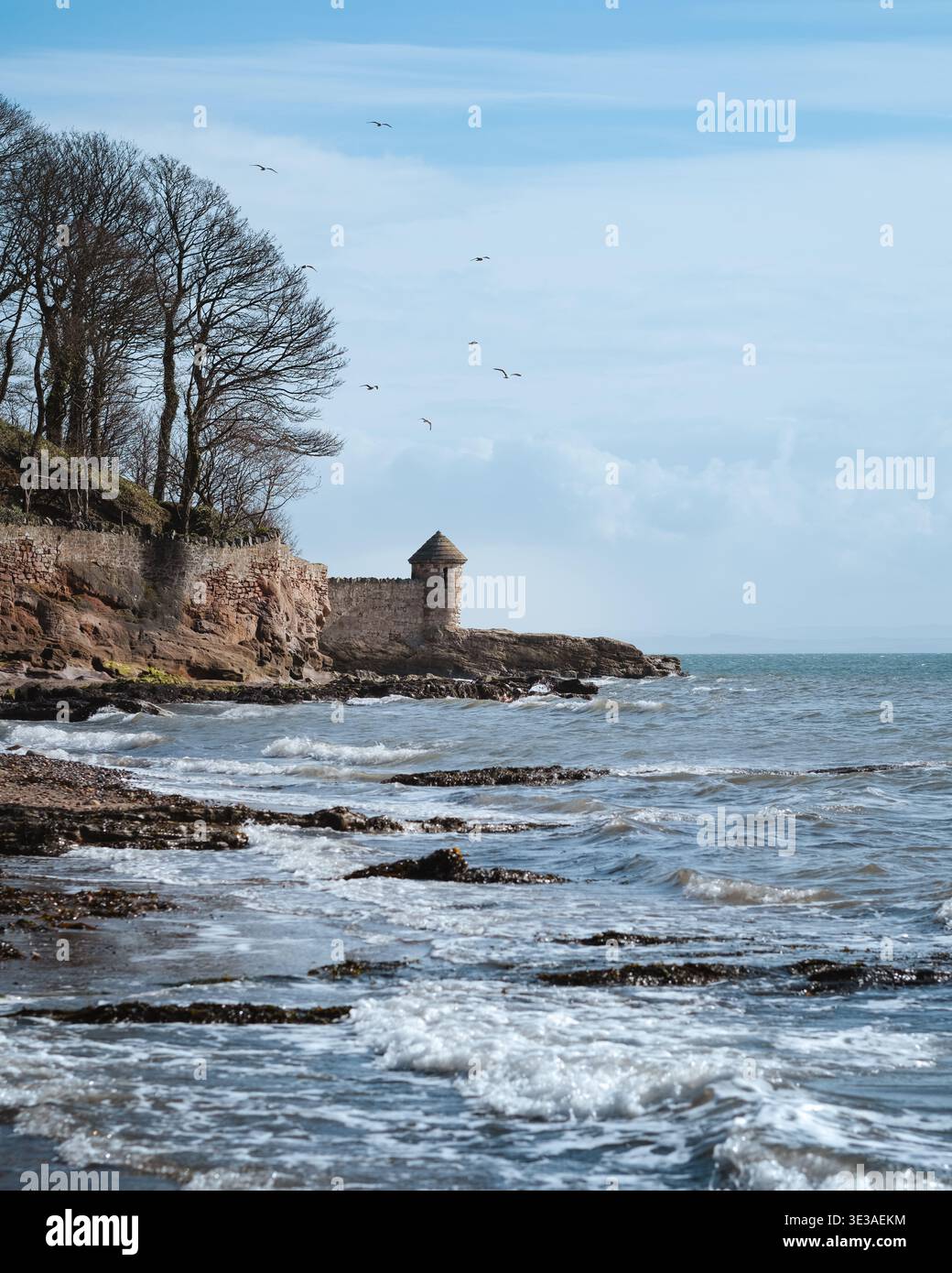 Tour d'observation en pierre à Ashlar Head au-dessus du port de Dysart près de Kirkcaldy, Fife, Écosse, avec des vagues se brisant le long du rivage rocheux Banque D'Images