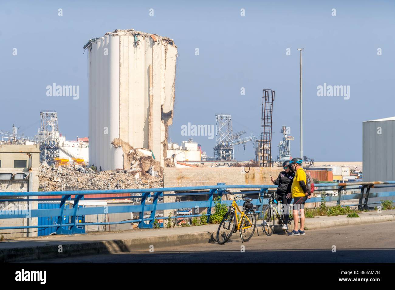 Lieu d'explosion dans le port de Beyrouth avec silos à céréales endommagés et débris au Liban, site de la catastrophe de 2020 du nitrate d'ammonium avec deux cyclistes. Banque D'Images