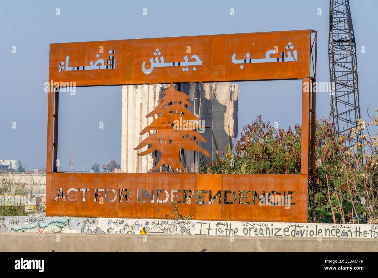 Panneau de protestation avec « ACTE POUR L'INDÉPENDANCE » et texte arabe encadrant le silo à céréales endommagé de l'explosion du port de Beyrouth en 2020 au Liban. Banque D'Images