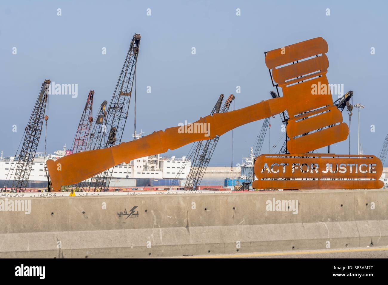 Panneau de protestation avec « AGIR POUR LA JUSTICE » encadrant le silo à céréales endommagé lors de l'explosion du port de Beyrouth en 2020 au Liban. Banque D'Images