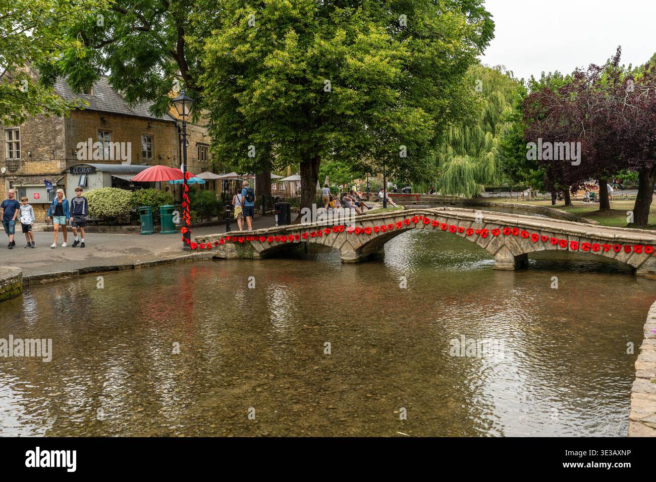 Une passerelle en pierre typique décorée de coquelicots à Bourton-on-the-Water, Cotswolds, Angleterre Banque D'Images