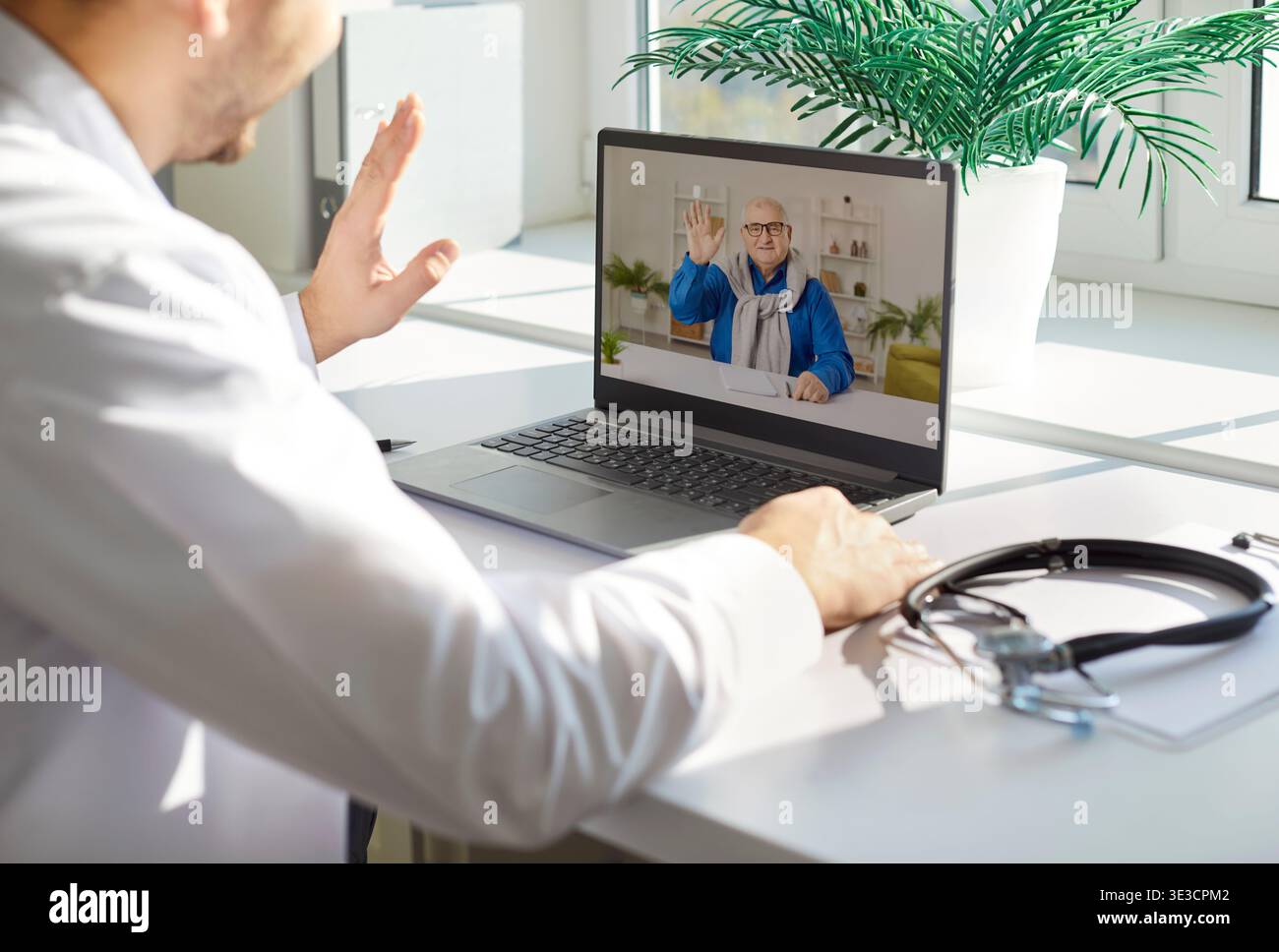 Le médecin mène une consultation virtuelle avec son patient senior masculin via un ordinateur portable. Banque D'Images