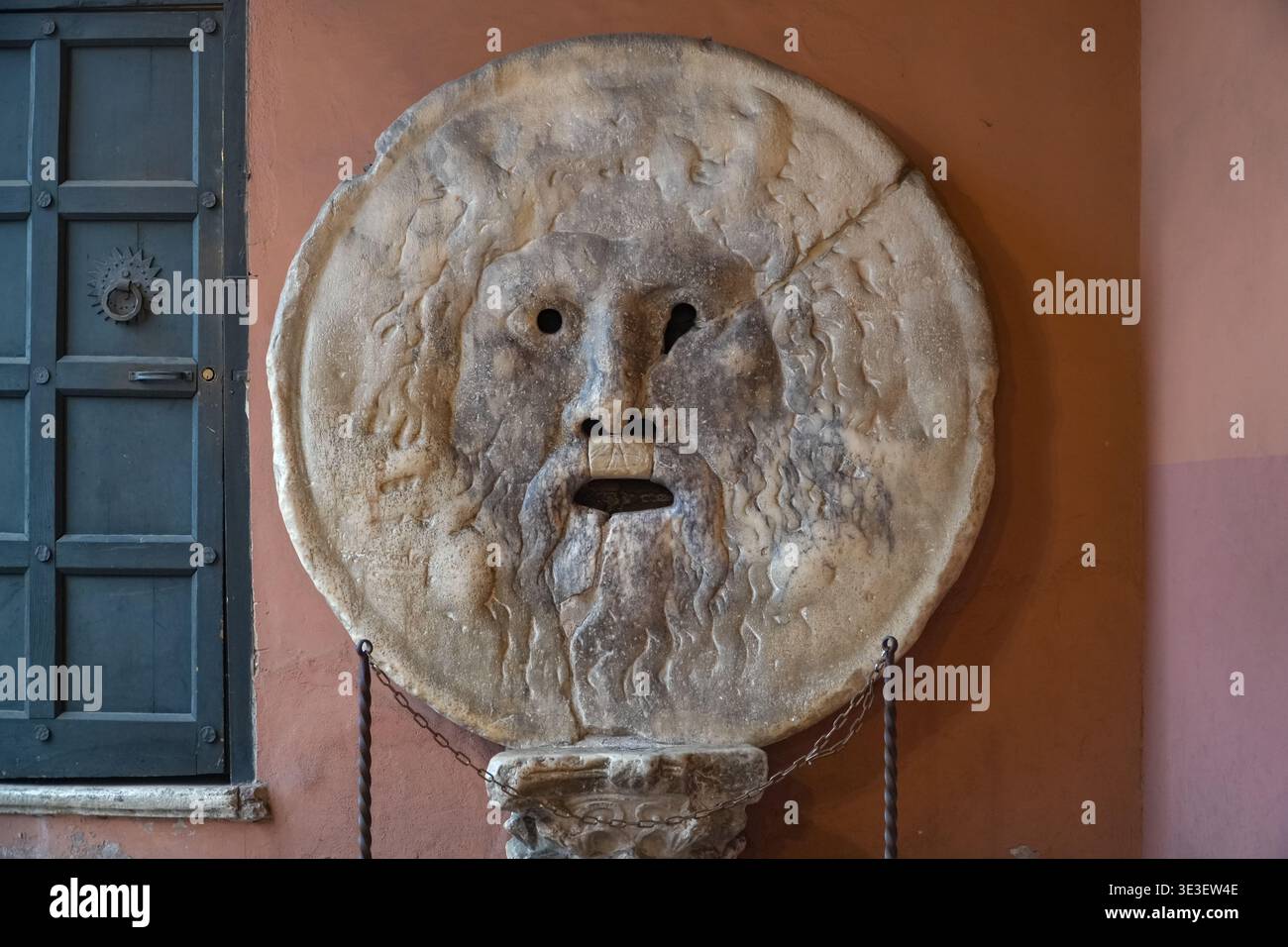 Bouche de vérité (Bocca della Verità). Rome, Italie. Ancienne sculpture romaine en marbre, célèbre pour son honnêteté, montée à côté d'une porte lambrissée. Banque D'Images