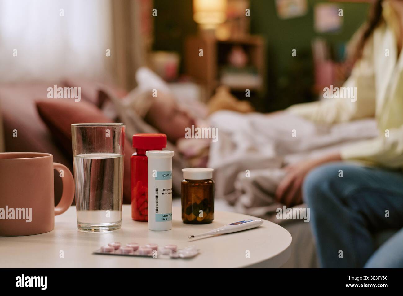Femme d'âge moyen prenant soin de l'enfant malade dans la chambre avec des médicaments Banque D'Images