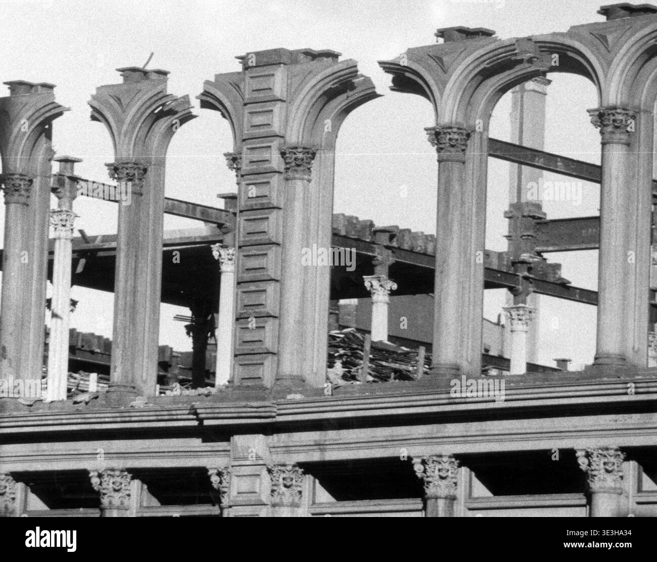 Cette superbe photographie en noir et blanc d'Angelo Rizzuto, probablement des années 1950, capture les restes squelettiques de ce qui semble être le bâtiment Wanamaker à New York après un incendie dévastateur. L'image se concentre sur les éléments architecturaux carbonisés et brisés, révélant des arches effondrées et des poutres d'acier exposées au milieu de la destruction, offrant un aperçu poignant du passé de la ville et de la nature transitoire de ses grandes structures. Banque D'Images