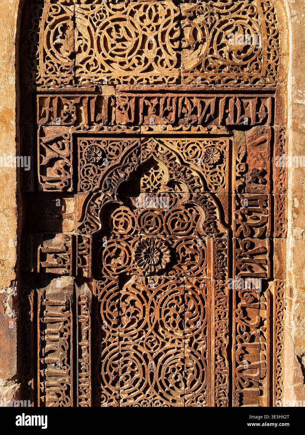 Calligraphie arabe complexe et sculptures géométriques sur mur de pierre Banque D'Images