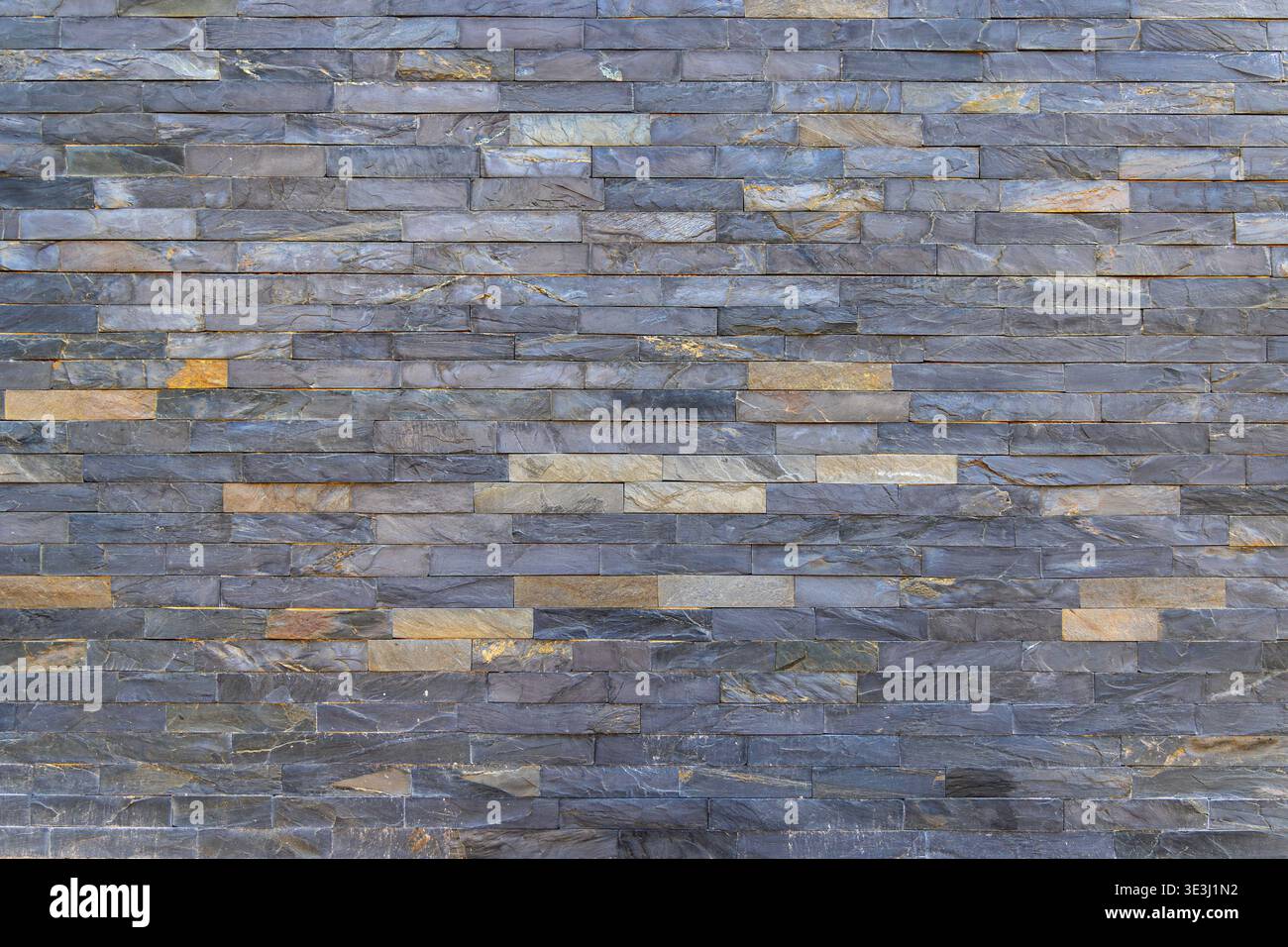 Texture de mur en pierre empilée bleu gris. Vue plein cadre d'un mur en pierre empilée gris bleu avec des morceaux d'ardoise horizontaux, variation naturelle et moderne Banque D'Images