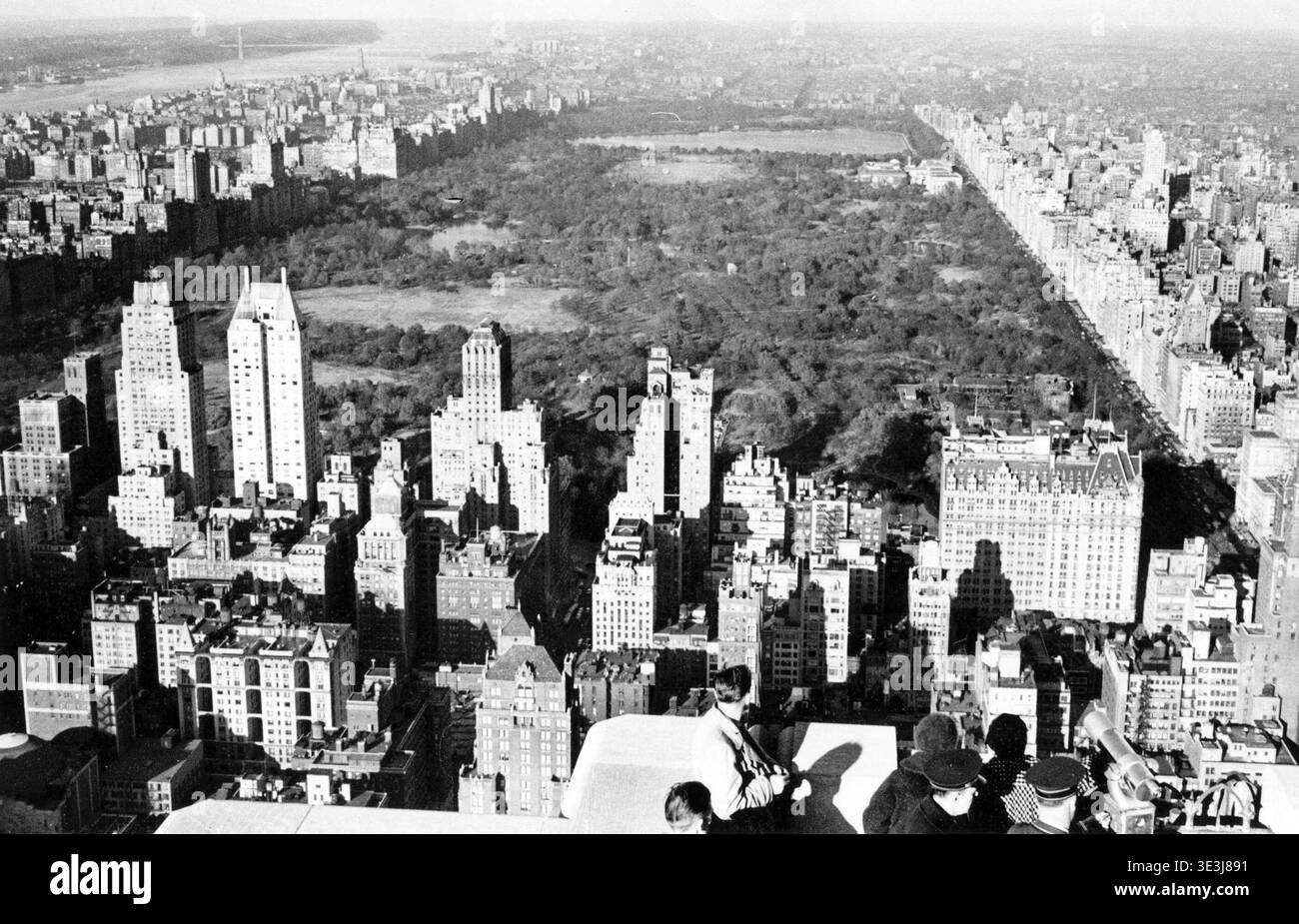 Cette superbe photographie aérienne en noir et blanc d'Angelo Rizzuto, probablement des années 1940, capture une vue panoramique de Manhattan regardant vers le nord en direction de Central Park. Les spectateurs surplombent le paysage urbain emblématique avec ses imposants bâtiments et l'étendue verdoyante du parc. La scène offre un aperçu de l'architecture New-yorkaise vintage et de la vie urbaine. Banque D'Images