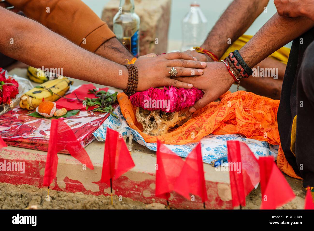 Gros plan de mains placées sur un crâne humain décoré lors d'un rituel tantrique à Dashashwamedh Ghat à Varanasi sur les rives du Gange. Vara Banque D'Images