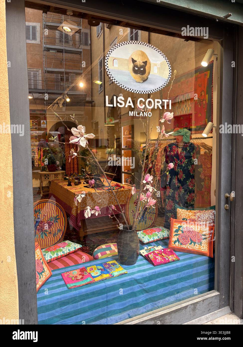 Vitrine de la boutique Lisa Corti Milano avec textiles vibrants, coussins, fleurs de magnolia et logo de chat sur la via dei Coronari, Rome, Italie. Banque D'Images