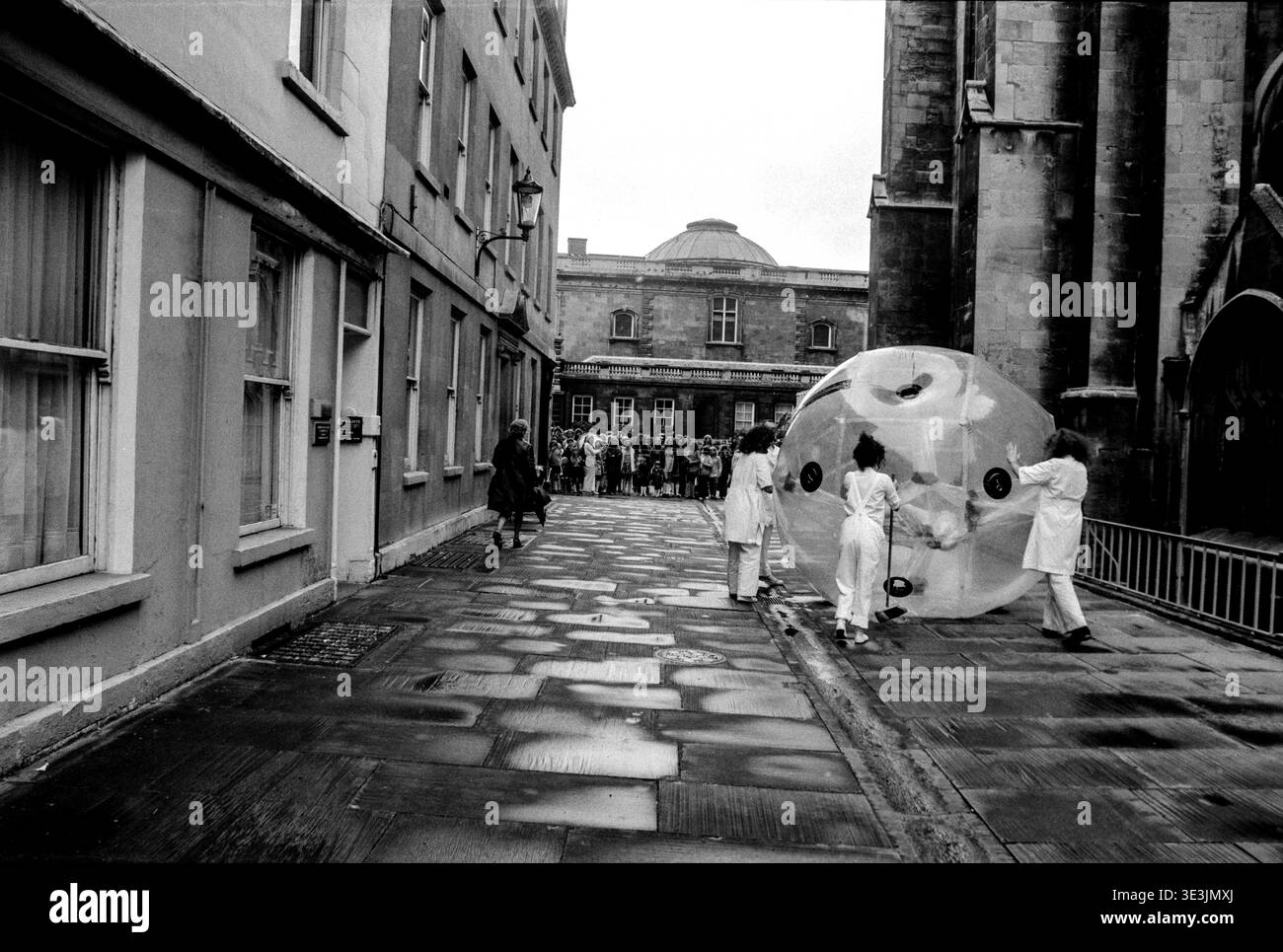 L'artiste de performance Gil Gillilan roule son ballon de performance le long du trottoir près de la cathédrale Saint-Paul lors d'une partie de son événement de théâtre de rue, 1974. Banque D'Images