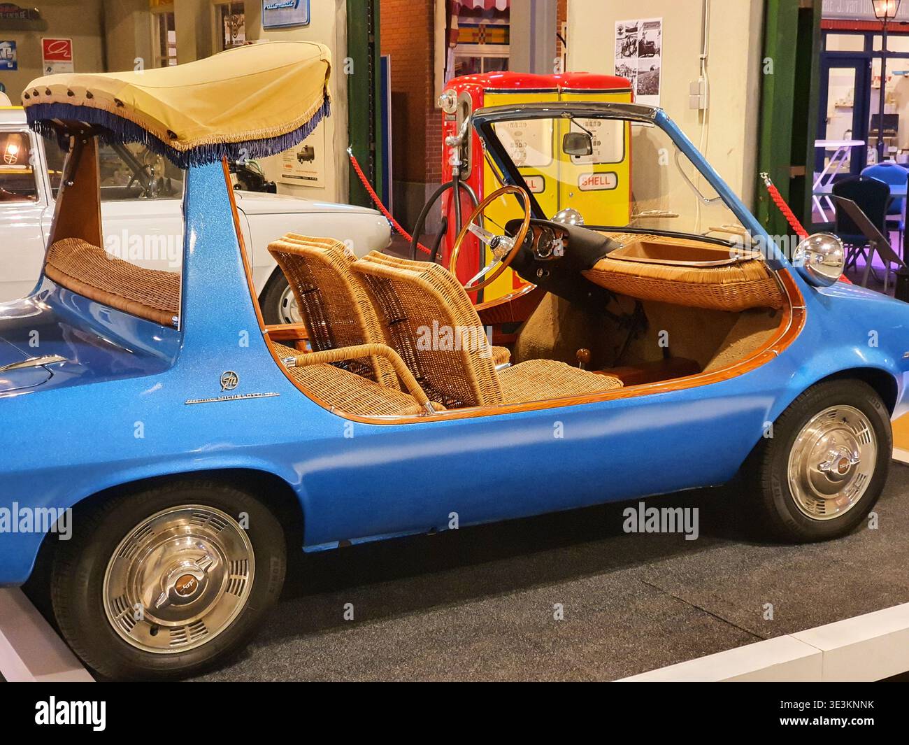 Une voiture de plage bleue vintage Fiat 600 Jolly exposée dans un cadre de musée. Le véhicule est doté de sièges et de garnitures intérieures distinctifs en osier et en rotin, Banque D'Images