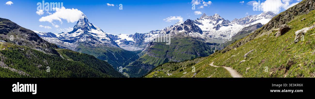 La vue sur les pics dentelés et enneigés perce le ciel bleu vibrant, contrastant avec les vallées verdoyantes et les sentiers sinueux, Zermatt, Valais, Switzer Banque D'Images